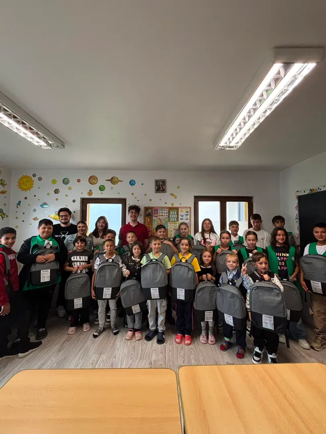 Copiii își primesc ghiozdanele noi, alături de voluntari