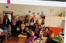Clasă de elevi cu ghiozdane noi, alături de voluntari și partenerii BIC