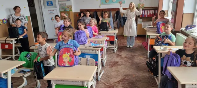 Copiii își arată ghiozdanele primite