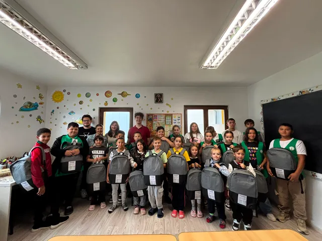 Copiii cu ghiozdanele primite, alături de voluntari
